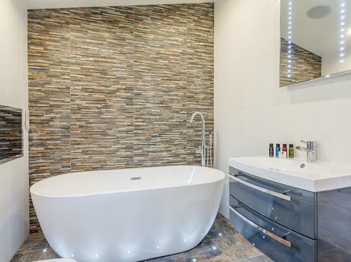 Family bathroom with large freestanding bath and TV built in to the wall