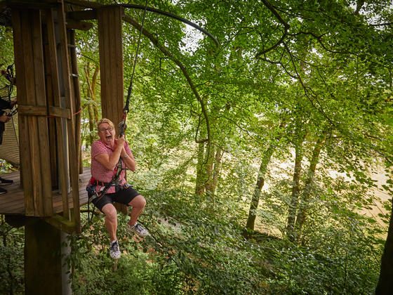 Young girl coming down zip wire at Go Ape