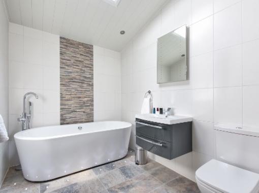 Modern bathroom with large freestanding bath and feature tile wall