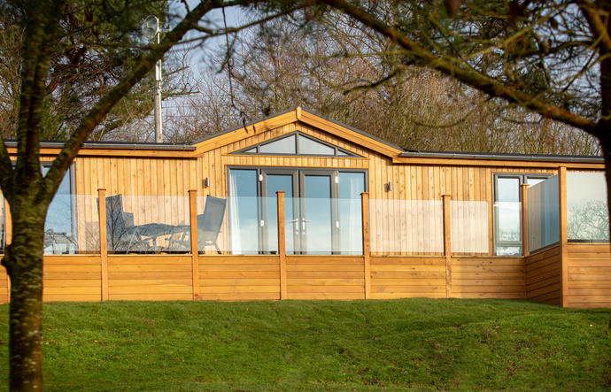 Modern and stylish lodge with glass screening to the decking area