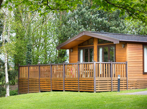 Pinelodge with decking looking on to grassy area